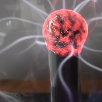Plasma globe with pink and purple electrical arcs against a dark background.