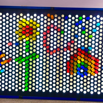 Colorful Lite-Brite design with flower and rainbow pattern.